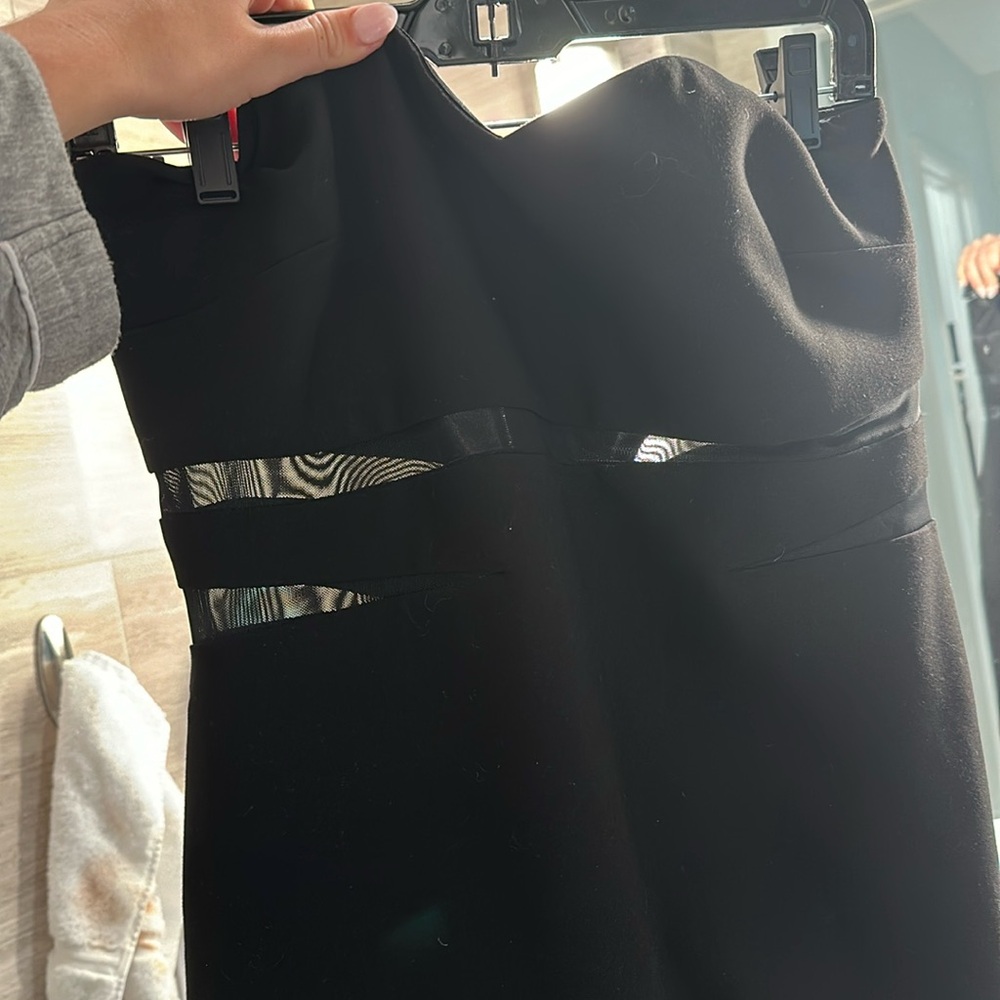 Likely black dress with mesh cutouts and a slit